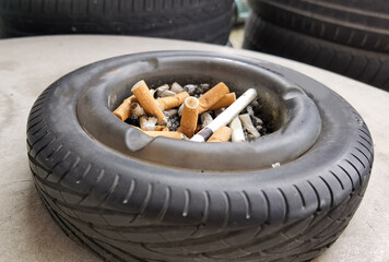 cigarette ashtray many garbage off burnt on a wheel of a car