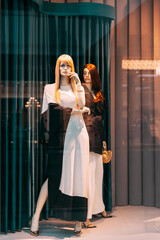 Female mannequin in shop window showcase of store mall market. Fashion clothes - dress, jacket. Mannequins dressed in female woman fashion clothes in store of shopping center. Showcase store.