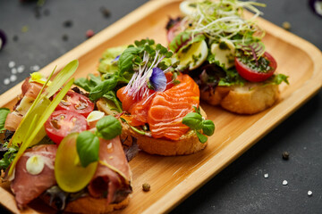 Assorted bruschetta set with salmon, parma and pesto souce. Italian antipasti snacks. Variety mix...