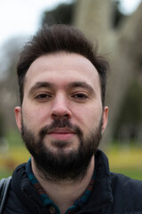 Fototapeta premium Portrait of man. No expression on his face. Outdoor background. Close up photo.