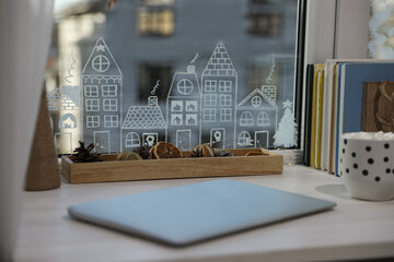 Obraz premium Laptop and hot drink on white wooden table near window with beautiful drawing at home. Christmas decor