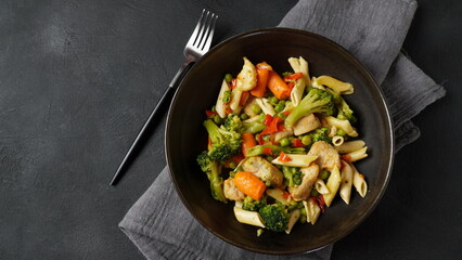 Pasta salad with baked vegetables and fried pieces of chicken breast
