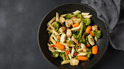 Pasta salad with baked vegetables and fried pieces of chicken breast