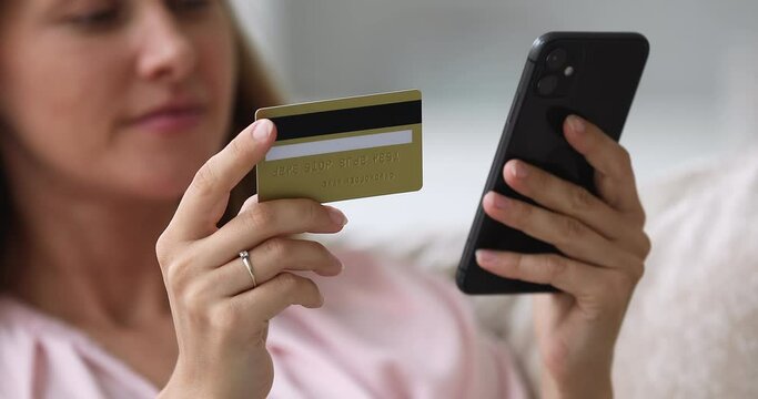 Instant successful money transfer use mobile app, spend funds online, do e-shopping concept. Close up female hands holds smartphone and credit card makes payment, pay on-line, enjoy shopping at home