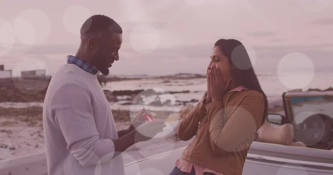 Animation Of Happy African American Man Proposing To His Biracial Girlfriend At Cabriolet