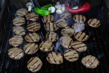 Fototapeta na wymiar Turkish Food Kofte or Kofta .Cheddar meatballs Kebab. Grilled patties on charcoal. Preparing a batch of grilled or barbecue ground meat patties or frikadeller.