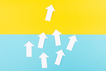 White arrows on a blue yellow background, one is standing out, do different, be a winner,...