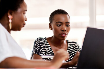 Applying new ideas to suit their business. Shot of two businesswomen working together on a laptop...