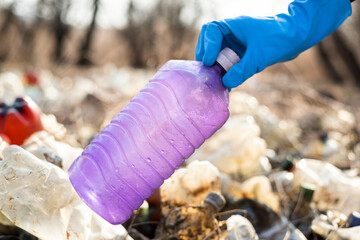 Man collecting scattered plastic bottles from the ground