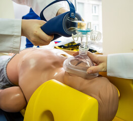 Medical Students practicing emergency cardiopulmonary resuscitation on a medical practice doll for...
