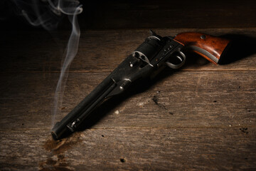 old west gun lays on floor after gunfight with smoke coming from barrel on saloon floor
