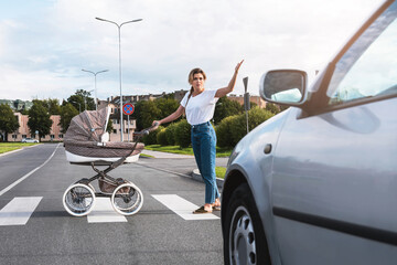 Outraged mother with the baby pram conflicting with a car's driver on the crosswalk