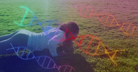 Animation of dna strands over biracial woman exercising in park - Powered by Adobe