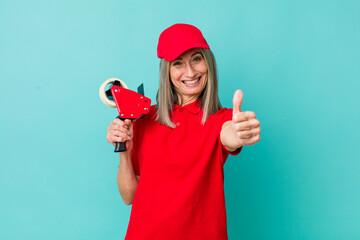senior gray hair woman feeling proud,smiling positively with thumbs up. packer employee concept