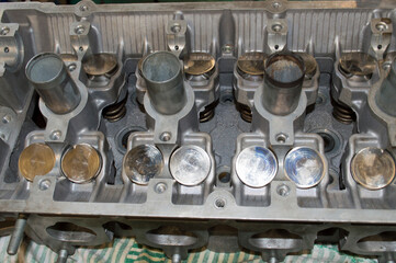 The inverted head of the car engine block lies on the desktop
