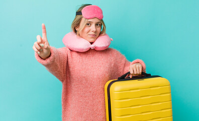 pretty blonde woman smiling and looking friendly, showing number one. flight passenger concept