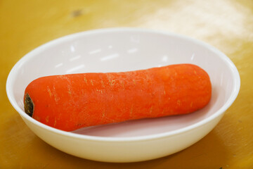 Freshly harvested carrots placed on a white plate