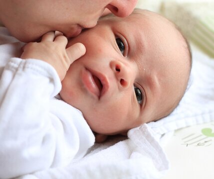 baby with his mother been cared for after having a good night sleep in bed at home stock photo 