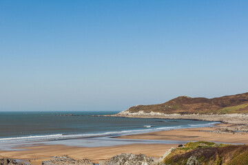 Sandy beach at low tide with people enjoying the sun and sea