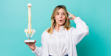 pretty blonde woman looking happy, astonished and surprised. spine specialist concept