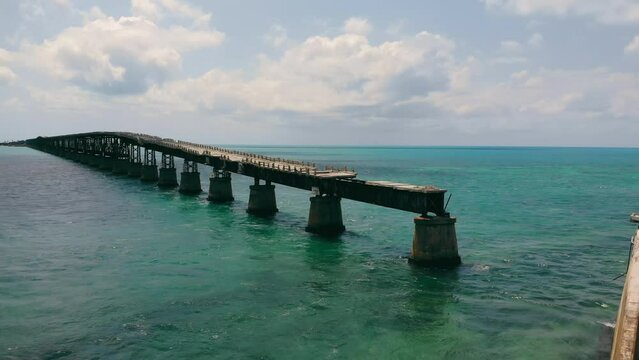 Broken bridge running over ocean surface in Florida Keys, USA. Aerial view from drone of old Bahia bridge along ocean with scenic horizontal oceanscape, with copy space. Concept of architecture