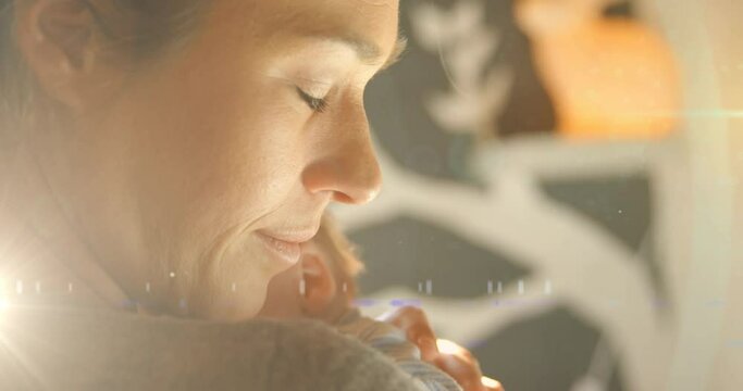 Animation Of Glowing Spots Over Happy Caucasian Mother With Sleeping Baby