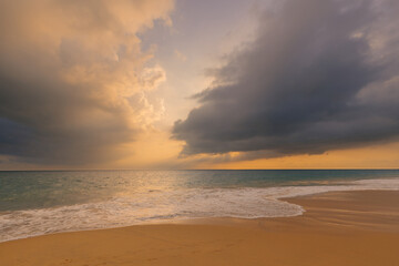Fototapeta na wymiar Foamy waves on the sandy ocean beach under a beautiful sunset sky with clouds on Sri Lanka island.