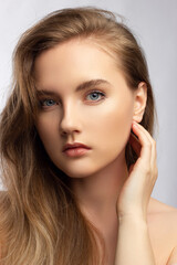 Fototapeta premium Beautiful woman with bright make up eye with sexy black liner makeup. Fashion big arrow shape on woman's eyelid. Natural lips. Chic evening make-up. Blonde long wave hair. Shining face skin
