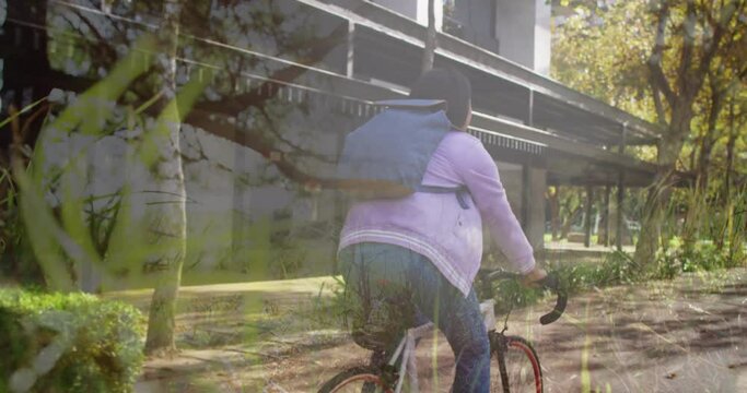 Animation of trees over african american woman cycling
