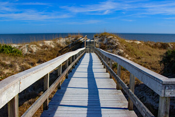 Fototapeta na wymiar boardwalk over sand dunes at ocean beach