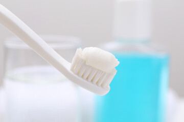 Fototapeta na wymiar Toothbrush with paste on blurred background, closeup