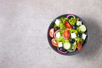 Greek salad with fresh tomatoes, cucumber, olives, feta cheese and red onion. Healthy and diet food concept.