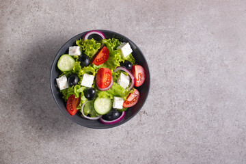 Greek salad with fresh tomatoes, cucumber, olives, feta cheese and red onion. Healthy and diet food concept.