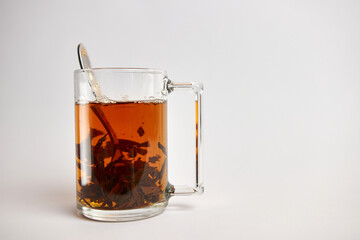 A glass of brewed black leaf tea.