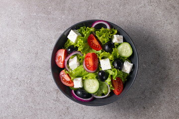 Greek salad with fresh tomatoes, cucumber, olives, feta cheese and red onion. Healthy and diet food concept.