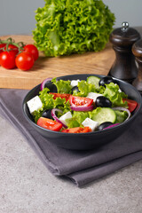 Greek salad with fresh tomatoes, cucumber, olives, feta cheese and red onion. Healthy and diet food concept.