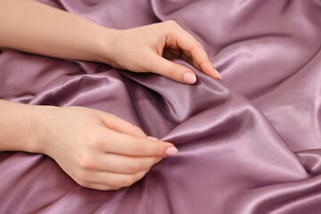 Fototapeta premium Woman touching smooth silky fabric, closeup view