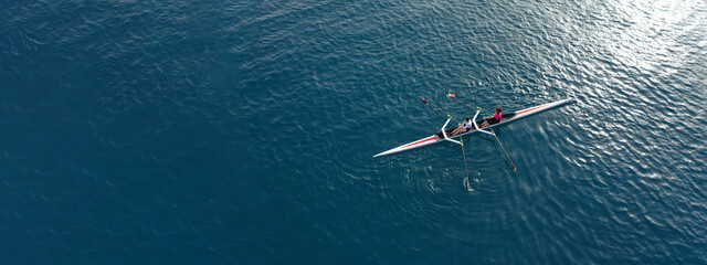 Aerial drone ultra wide top down panoramic photo with copy space of sport canoe operated by young woman in deep blue calm sea waters