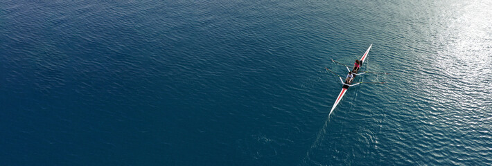 Aerial drone ultra wide top down panoramic photo with copy space of sport canoe operated by young woman in deep blue calm sea waters © aerial-drone