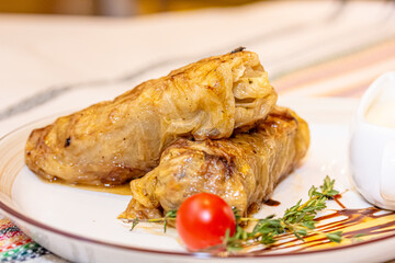 Stuffed cabbage rolls with meat on a plate with sour cream
