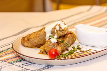 Stuffed cabbage rolls with meat on a plate with sour cream