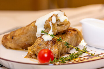 Stuffed cabbage rolls with meat on a plate with sour cream