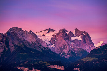 The tops of the mountains are covered with snow,  Switzerland