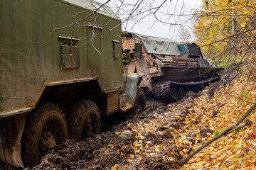 Fototapeta na wymiar The truck got stuck on a dirty, broken forest road. Autumn thaw. Offroad