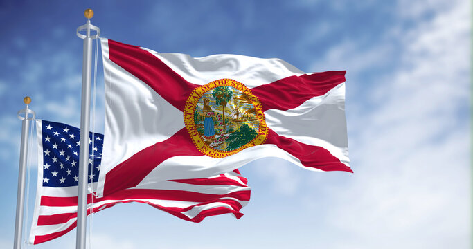 The Florida state flag waving along with the national flag of the United States of America