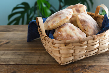Wooden basket with several pieces of pita bread. Copy space.
