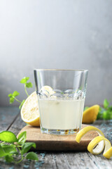 Glass of lemon water in the early morning on a wooden background with a copy space.