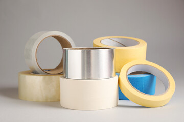 Many rolls of adhesive tape on light grey background