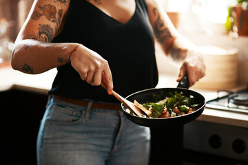 Stir fry, the healthy choice. Cropped shot of a woman preparing a meal at home.