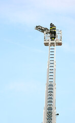Obraz premium fireman on the basket of the ladder truck during the rescue of an injured person